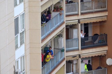 Huelva, İspanya - 9 Nisan 2020: Vatandaşlar ölümcül koronavirüs salgını sırasında her gün saat 8 'de evlerinde balkonlarda alkışlıyorlar. İspanya 'da karantinadaki insanlar
