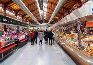 Colmar, Fransa - 1 Aralık 2019: Colmar, Alsace bölgesinin tarihi yenilenmiş pazarının iç görünümü. Odunlu metalik bir yapı. Ana cadde boyunca birçok dükkan var. Taze ürün.