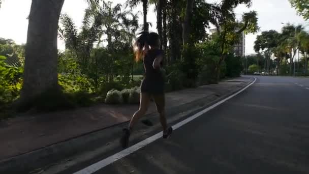 Молодая женщина бежит на закате в замедленной съемке — стоковое видео