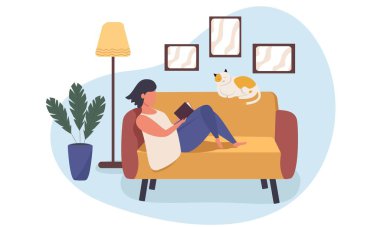Kadın kanepede uzanıyor ve kitap okuyor. Bir kedi kanepede uyuyor..