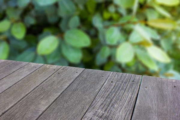 Placa de madeira mesa vazia na frente do fundo borrado — Fotografia de Stock