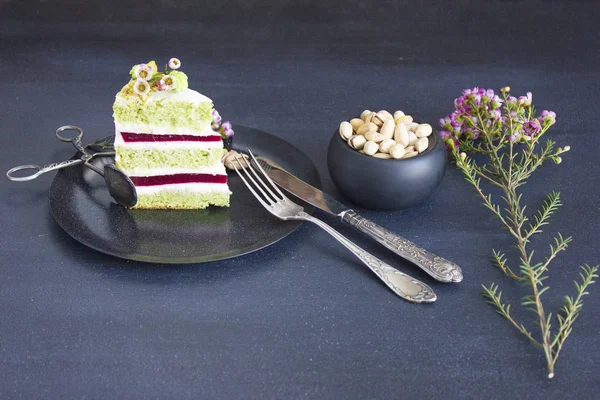 A piece of the cake with raspberry filling and pistachios — Stock Photo, Image