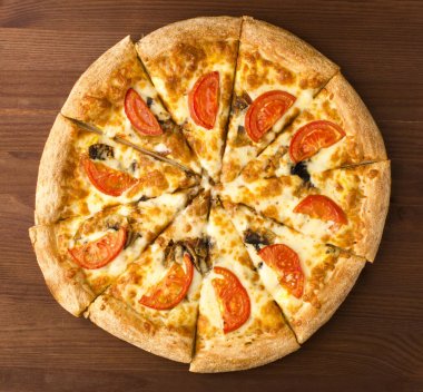 Domates ve ahşap arka plan üzerinde mantarlı pizza