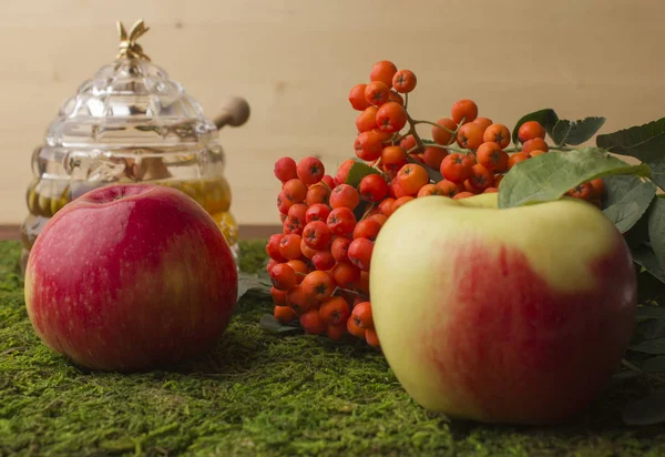 Ripe apples and fruits of red mountain ash with green leaves. — Stock Photo, Image