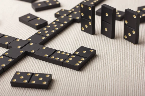 Dominoes are black. Light background.