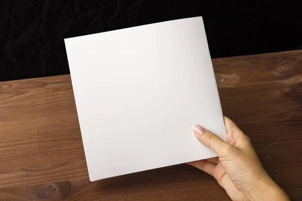 Livre blanc vide pour notes, cahier, journal, livret, organisateur à la main sur une table en bois . — Photo