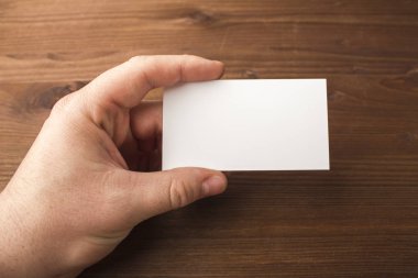 Boş kartvizit el ahşap arka plan üzerinde. Tasarımlarınız için