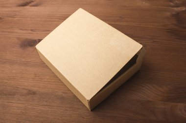 Karanlık, ahşap arka plan üzerinde karton kutu