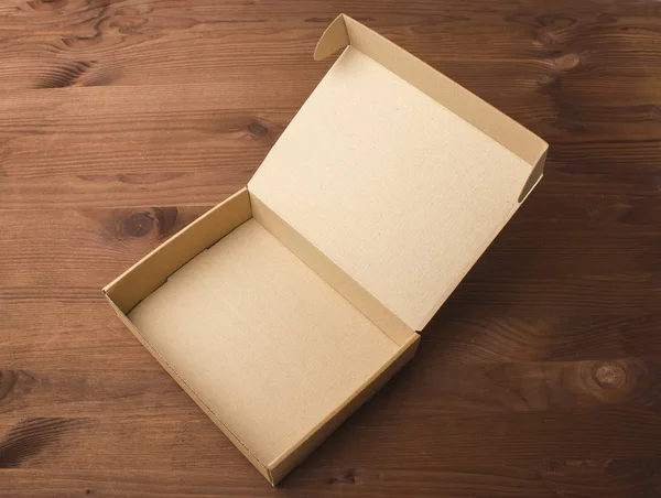 Картонна коробка на темному, дерев'яному фоні — стокове фото