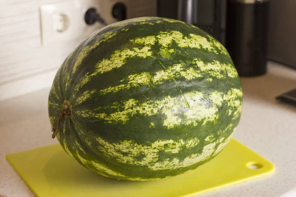 Uma melancia inteira na placa da cozinha — Fotografia de Stock