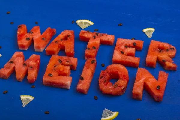 A palavra melancia de pedaços de melancia com ossos e limão — Fotografia de Stock