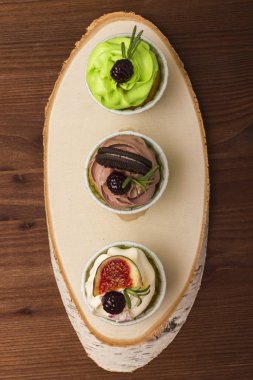 Huş ağacı ahşap bir kesim üzerinde üç top kek. Ahşap arka plan. Lezzetli bir tatlı