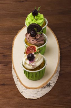 Huş ağacı ahşap bir kesim üzerinde üç top kek. Ahşap arka plan