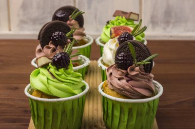 Bir ahşap tahta üzerinde üç top kek. Ahşap arka plan.