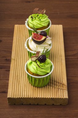 Bir ahşap tahta üzerinde üç top kek. Ahşap arka plan 