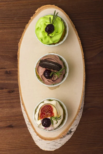 Huş ağacı ahşap bir kesim üzerinde üç top kek. Ahşap arka plan. Lezzetli bir tatlı