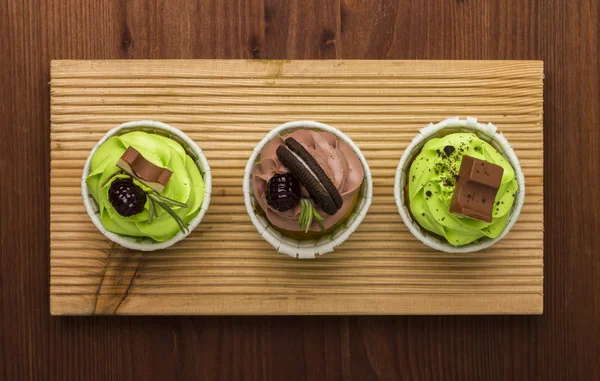 Bir ahşap tahta üzerinde üç top kek. Ahşap arka plan. Lezzetli bir tatlı