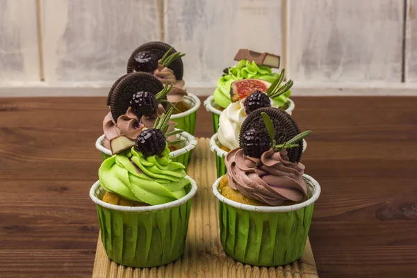 Bir ahşap tahta üzerinde üç top kek. Ahşap arka plan. 