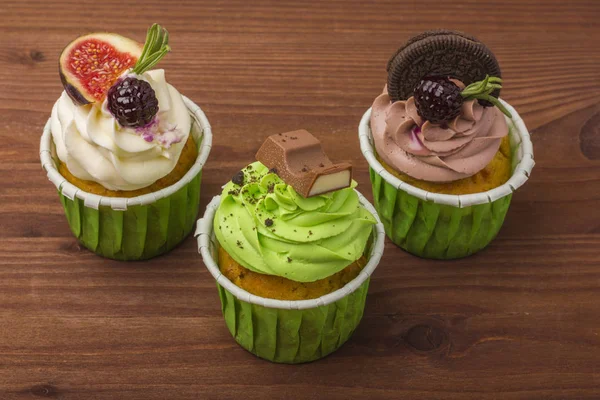 Cupcakes ahşap arka plan üzerinde bir dizi. 