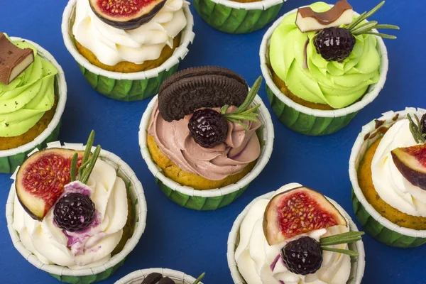 Mavi bir arka plan üzerinde cupcakes kümesi. Lezzetli bir tatlı