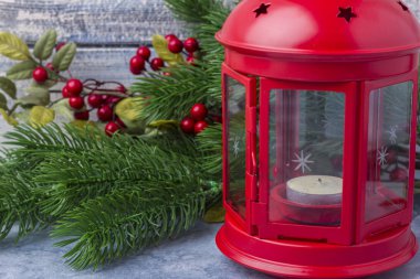 Kırmızı mum içinde bir mum ve bir Noel ağacı dalı. Noel ve yeni yıl Tema