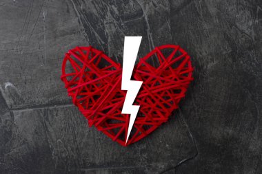 Kırık kalp karanlık bir arka plan üzerinde ikiye. Yukarıdan görüntülemek