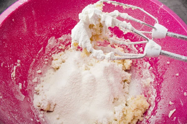 Mix the dough with a hand mixer on the background of the kitchen table with the ingredients for cooking. Dough for pie