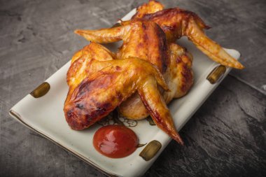 Tavuk kanadı karanlık bir arka plan üzerine bir tabak. Çıtır kızarmış tavuk 