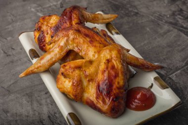 Tavuk kanadı karanlık bir arka plan üzerine bir tabak. Çıtır kızarmış tavuk 