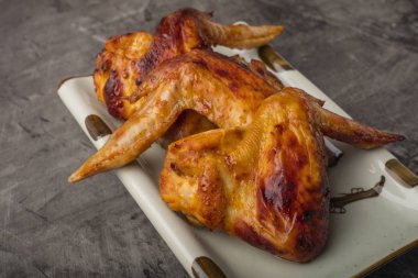 Tavuk kanadı karanlık bir arka plan üzerine bir tabak. Çıtır kızarmış tavuk 