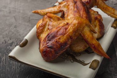 Tavuk kanadı karanlık bir arka plan üzerine bir tabak. Çıtır kızarmış tavuk 