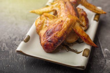 Tavuk kanadı karanlık bir arka plan üzerine bir tabak. Çıtır kızarmış tavuk 