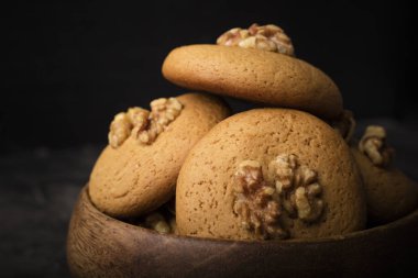 Ceviz ahşap bir kase ile bisküvi tatlım. Koyu arka plan. ev yapımı yiyecek 1