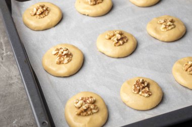 Bir fırın tepsisine parşömen kağıt, pişirme için hazır ile ceviz ile ham bal bisküvi. 1 yemek ev