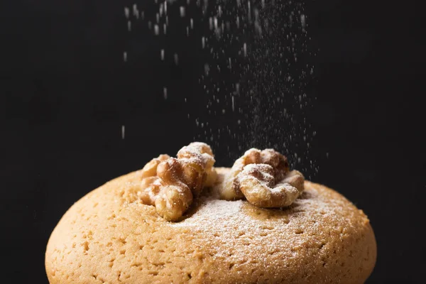Honey cookies with walnuts sprinkled with powdered sugar on a dark background. homemade food 1
