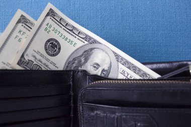 Mavi bir arka plan üzerinde siyah bir çanta para. Dolarlık banknot 2