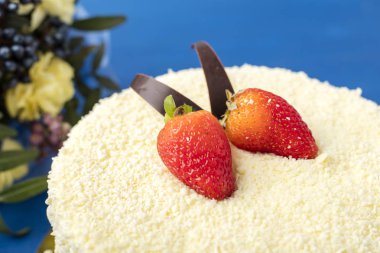 Beyaz çikolata ve taze çilek pasta. Mavi bir arka plan üzerinde lezzetli tatlı 