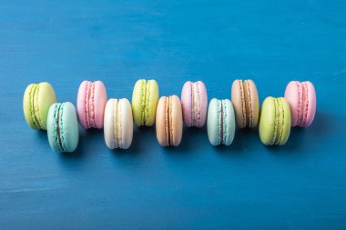 Pasta macaron veya yukarıdan, renkli Badem Çerezler, pastel renkler, vintage kartı, üstten görünüm mavi arka plan üzerinde acıbadem kurabiyesi. Kopya alanı 1