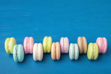 Pasta macaron veya yukarıdan, renkli Badem Çerezler, pastel renkler, vintage kartı, üstten görünüm mavi arka plan üzerinde acıbadem kurabiyesi. Kopya alanı 1
