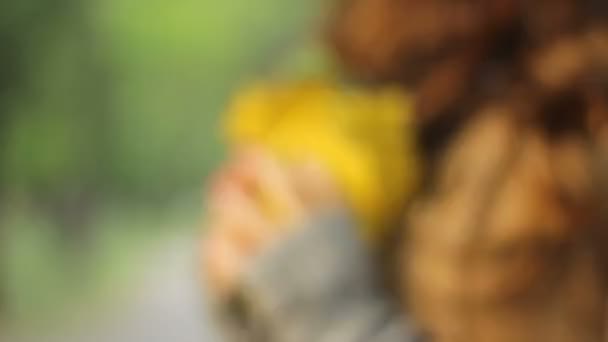Dziewczyna trzyma bukiet żółty odchodzi w jej ręce i bawi się z nim — Wideo stockowe
