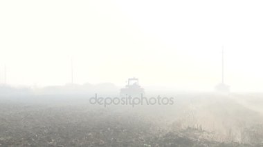 bir adam ve bir traktör siste