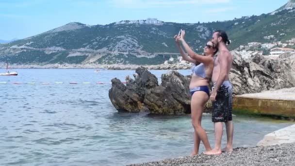 Пара бере селфі на пляжі — стокове відео