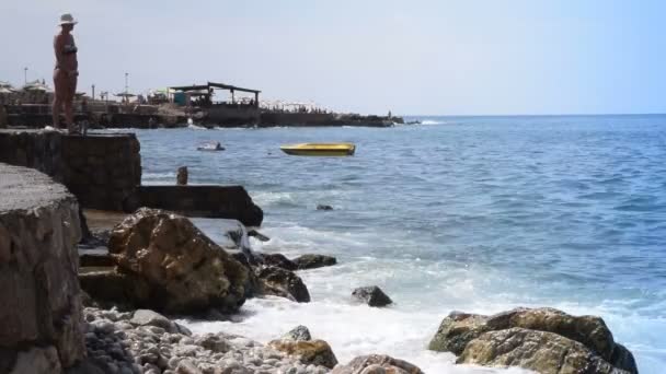 Mujer de pie en la playa fortificada — Vídeo de stock