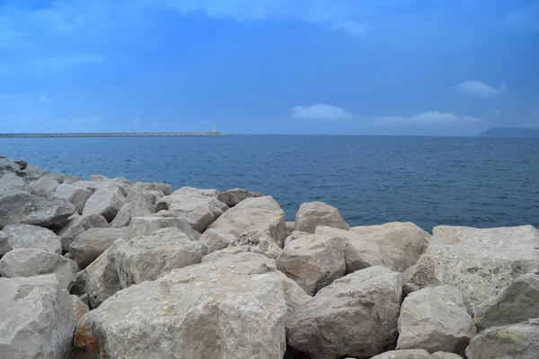Mavi deniz, kara ve deniz sınırları, deniz feneri taş duvar — Stok fotoğraf