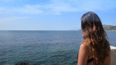 bikinili genç kadın açık denizin tadını çıkarmak için balkona çıkar