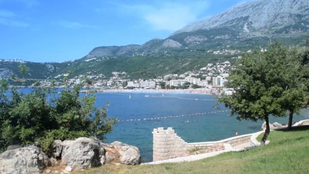 Glade près de la mer et nageurs en arrière-plan — Video