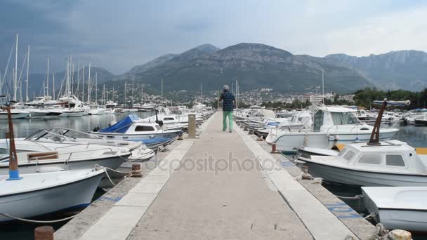 Hombre de mediana edad llamando y pasando por el puerto — Vídeos de Stock