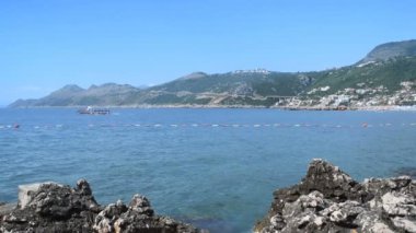 kayaların üzerinde kıyıya ve yelkenli tekne içinde belgili tanımlık geçmiş