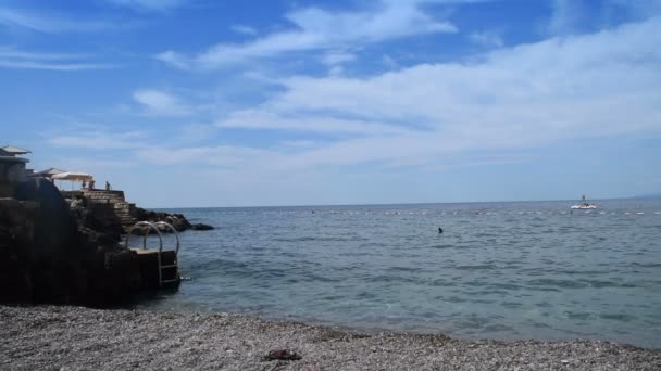 Escaleras que conducen al mar, sombrillas de playa y botes de pedal en el fondo, dos disparos — Vídeos de Stock