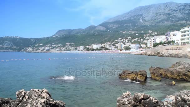 Rocas en la costa y la ciudad costera en el fondo — Vídeos de Stock